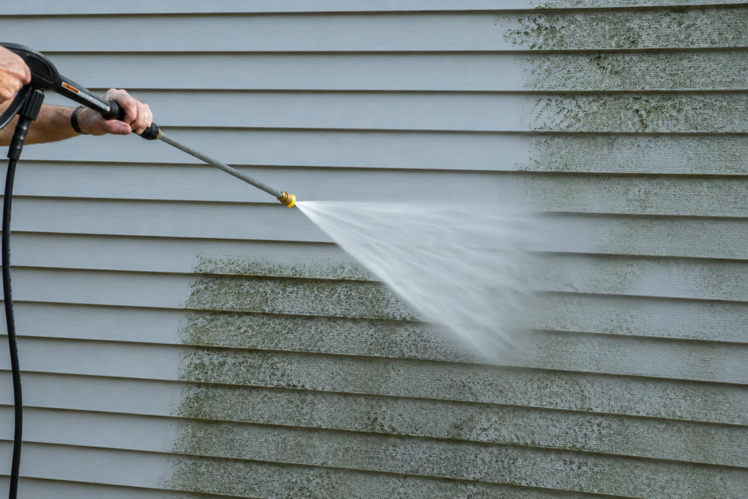 Pressure washing siding to remove algae and exterior buildup